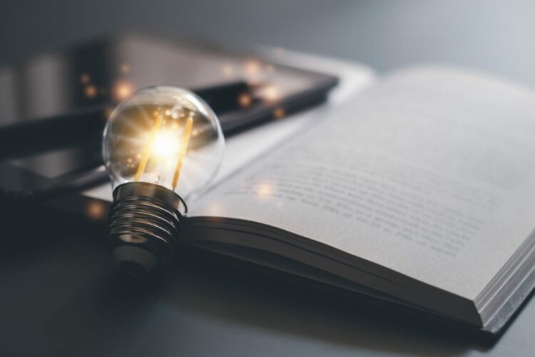 Glowing light bulb with a book