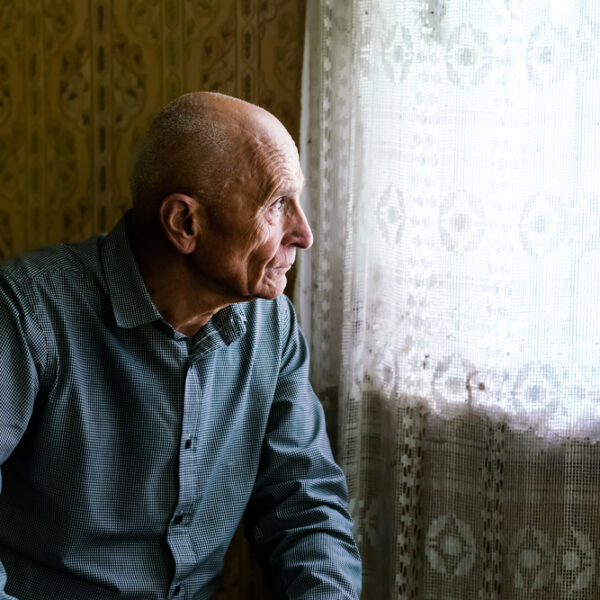 Elderly man sitting looking out the window