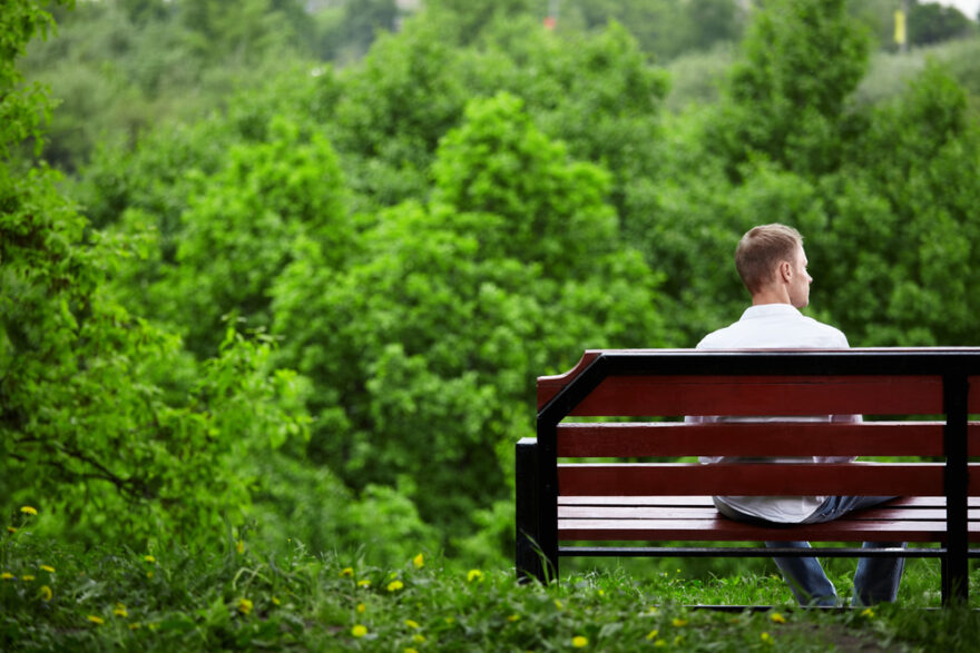 Young man sitting alone on a bench